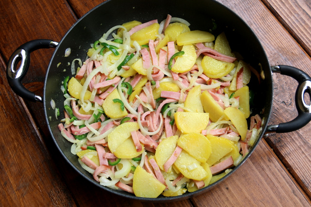 用火腿、洋葱和辣椒一起煮熟土豆