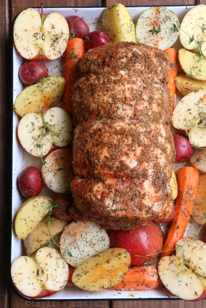 Seasoned pork loin ready to roast with apples and vegetables