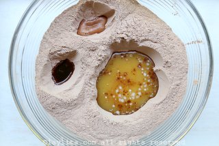在面粉混合物中开3个孔，较大放融化黄油，较小的两个放香草和醋